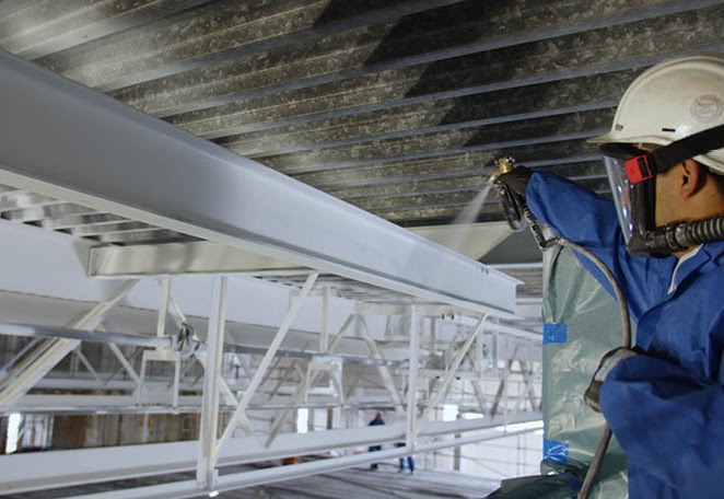 Protective coating being sprayed onto steelwork